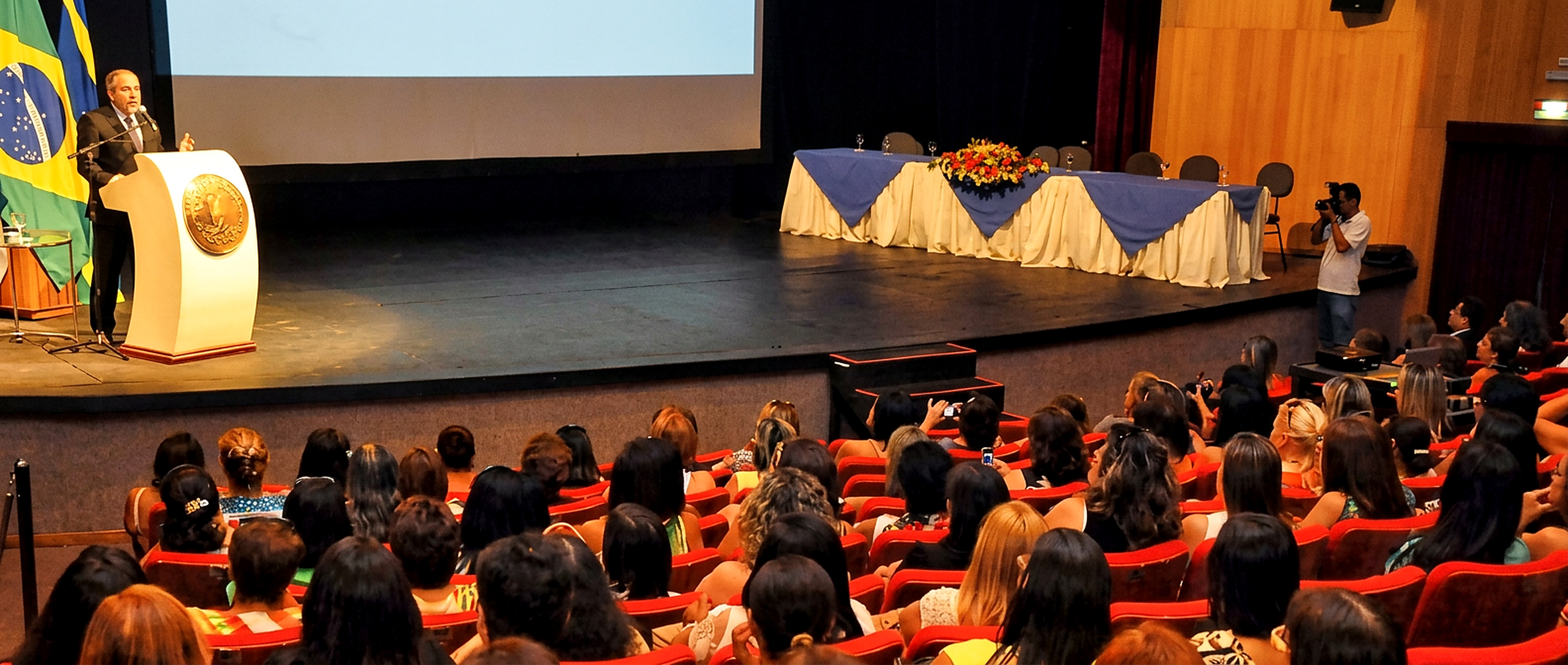 Augusto Dutra palestrando em teatro para plateia