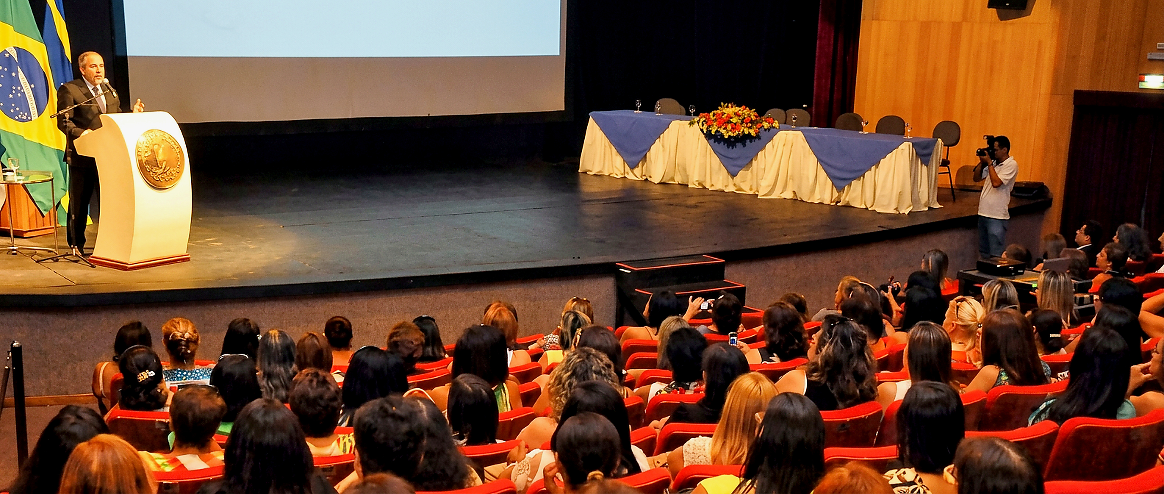 Augusto Dutra palestrando em teatro para plateia