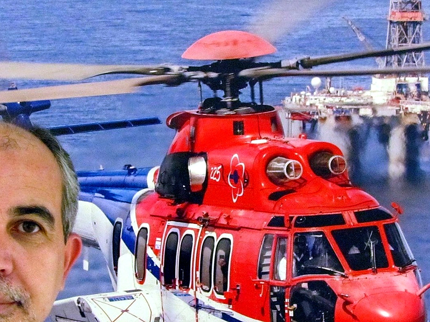 Augusto Dutra no heliponto de Farol de São Tomé, com helicóptero e plataforma da Bacia de Campos ao fundo